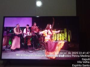 ヴィラ・ヴェーリャにあるAp do Danのテレビ画面上のステージ上の人々の集団