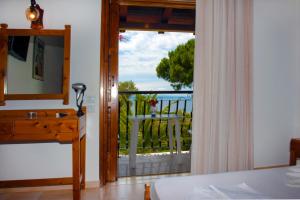 a bedroom with a door open to a balcony at Villa Anna Maria in Agia Paraskevi