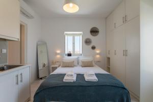 a bedroom with a large bed with towels on it at Ventus Studios in Ano Mera