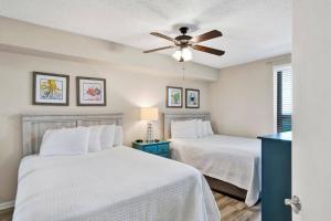 une chambre avec deux lits et un ventilateur de plafond dans l'établissement Summer House 1402A, à Romar Beach 42 autres photos