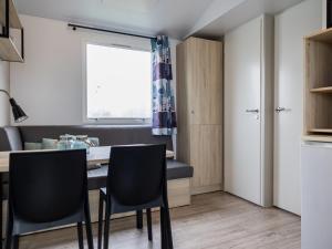 a kitchen and dining room with a table and chairs at 4 person chalet in the countryside 3 bedrooms in De Veenhoop