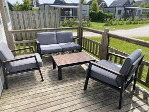 two chairs and a coffee table on a deck at 4 person chalet in the countryside 3 bedrooms in De Veenhoop