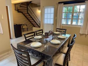 a dining room with a table and chairs and a staircase at Espacioso Departamento Céntrico in Formosa