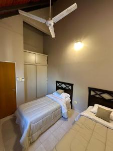 a bedroom with two beds and a ceiling fan at Espacioso Departamento Céntrico in Formosa +11 photos
