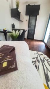 a living room with a white couch and a television at Alojamiento Borde Río habitación in Concepción +5 photos