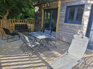 un patio avec une table et des chaises sur une terrasse dans l'établissement La Cabane du bois l'abbé, à Saint-Martin-Boulogne