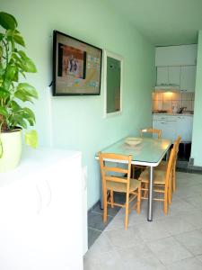 a kitchen with a table and chairs and a television at Apartmani ROKO in Neum