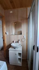 a bathroom with a white sink and a mirror at Cabaña Aeropuerto el Tepual in Puerto Montt