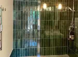 a bathroom with a shower with green tiles at Villa Brigitte in Le Touquet-Paris-Plage