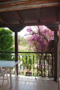 a view from a porch with a tree with purple flowers at Villa Anna Maria in Agia Paraskevi