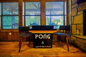 a table with two chairs and a box on it at After the Sunset 1-Level 5BR Pool - Arcade in Broken Bow +59 photos
