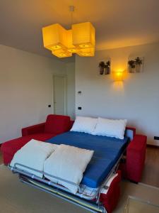 a bedroom with a bed and two red chairs at Casa Sant Anna Golf in Cogoleto