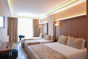 a hotel room with two beds and a desk at İstport Hotels in Arnavutköy