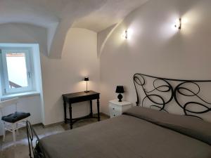 Un dormitorio con una cama y una ventana y una mesa. en Appartamento Luca, en Tiarno di Sotto