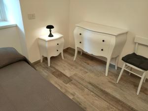 1 dormitorio con 1 cama, vestidor y silla en Appartamento Luca, en Tiarno di Sotto