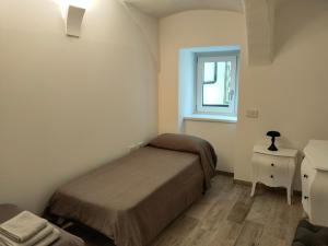 Un dormitorio pequeño con una cama y una ventana. en Appartamento Luca, en Tiarno di Sotto