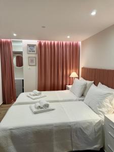 a hotel room with two beds with towels on them at Lucky Home Chios in Chios