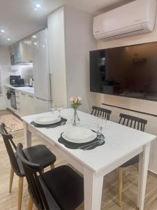a white dining room table with chairs and a kitchen at Lucky Home Chios in Chios
