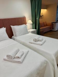 two white towels on two beds in a room at Lucky Home Chios in Chios +17 photos