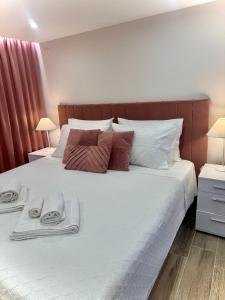 a bed with two towels and two lamps on it at Lucky Home Chios in Chios