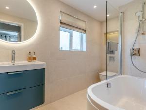 a bathroom with a tub and a sink and a mirror at 3 Bed in Bamburgh 90351 in Belford +14 photos