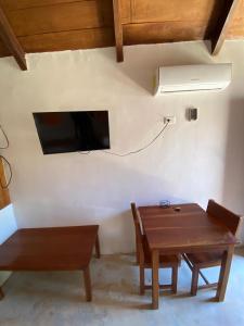a room with a table and a tv on a wall at For Large group, UP TO 10 people Entire Space Rental 3 lodges with private pools in Holbox Island