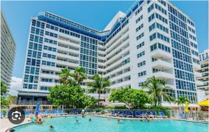 a swimming pool in front of a large building at Ocean Front on Fort Lauderdale Beach 2 br Condo Apartment in Fort Lauderdale