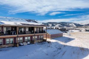 a house in the snow with snow covered mountains at Modern Granby Wonder by Leavetown Vacations in Granby