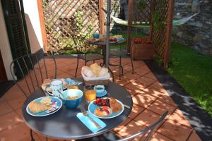 uma mesa com comida para o pequeno-almoço no pátio em Ca da Muntà bed and breakfast em Arenzano