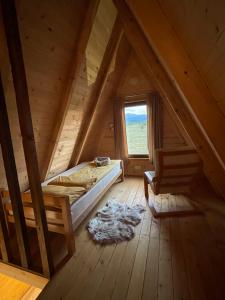 an attic room with a bed and a window at Warm home 2 Zabljak in Žabljak