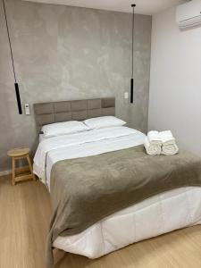 une chambre avec un grand lit avec des serviettes dessus dans l'établissement Espaço Gentileza Moderno Studio na Lapa, à Rio de Janeiro