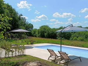 two chairs and umbrellas next to a swimming pool at Glamping Dôme Benzène in Fonmourenne