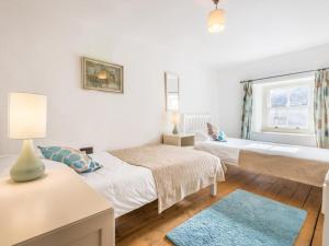 a bedroom with two beds and a blue rug at 3 Bed in Broughton-in-Furness SZ458 in Broughton in Furness +6 photos