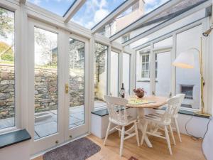un giardino d'inverno con tavolo, sedie e finestre di 3 Bed in Broughton-in-Furness SZ458 a Broughton-in-Furness