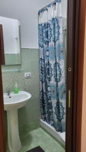a bathroom with a sink and a shower curtain at la finestra sul cortile 2 in Santa Procula Maggiore +12 photos