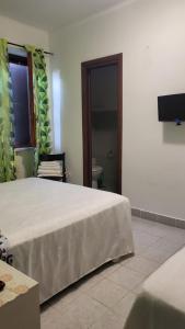 a hotel room with a bed and a television at la finestra sul cortile 2 in Santa Procula Maggiore