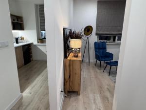 a living room with a table and a blue chair at Helenka Loft House 24H - Zabrze blisko A1, Arena Gliwice 15 min in Zabrze