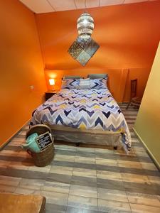 a bedroom with a bed with an orange wall at 1961 Los Naranjos Hostal in Los Naranjos