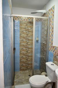 a bathroom with a toilet and a glass shower at 10 Céntrico y Confortable apto Casa Doña Yola in Cartagena de Indias