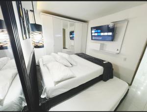 a bedroom with a bed with a mirror and a tv at Moderno apto low cost 15 min CC buena vista 2 TV con parqueadero comunal in Barranquilla