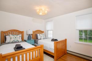 Un dormitorio con dos camas y una ventana. en Harwich Getaway by Leavetown Vacations, en Harwich