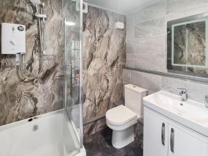 a bathroom with a shower and a toilet and a sink at Rock Cottage in Brassington +8 photos