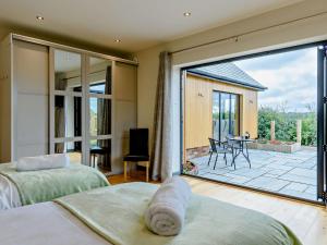 a bedroom with a large sliding glass door with a patio at 4 bed in Bodle Street Green 91157 in Warbleton