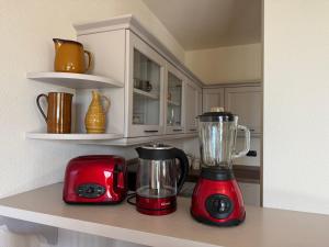 two red appliances sitting on a shelf in a kitchen at Dolce Vita in Tremezzo