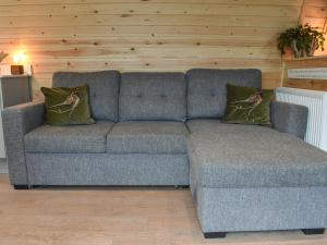 a blue couch with two pillows in a living room at Lakeview Lodge- Uk40692 in Crowhurst