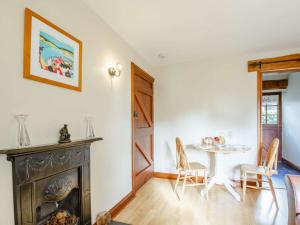 a dining room with a table and a fireplace at 1 Bed in Barmouth 89777 in Dyffryn