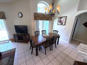 a dining room with a table and chairs and a television at Updated Golf Course View Villa - Southern Dunes in Haines City +29 photos