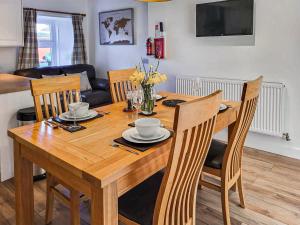 mesa de comedor con sillas y mesa de madera en Jessamine Cottage, en Blairgowrie