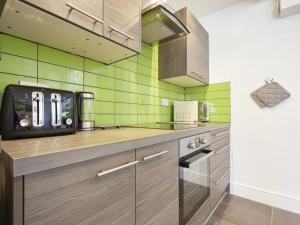Una cocina con azulejos verdes en la pared. en 2 Bed in Keswick SZ011, en Keswick