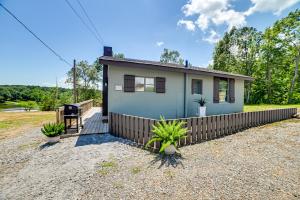 a small blue house with a wooden fence at Private Dock and Slip Kentucky Lake Cottage! in Buchanan